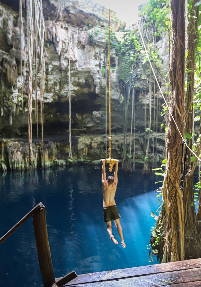 Travelers enjoy a rope swing at Cenote San Lorenzo Oxman, a scenic cenote in Mexico's Yucatan region.